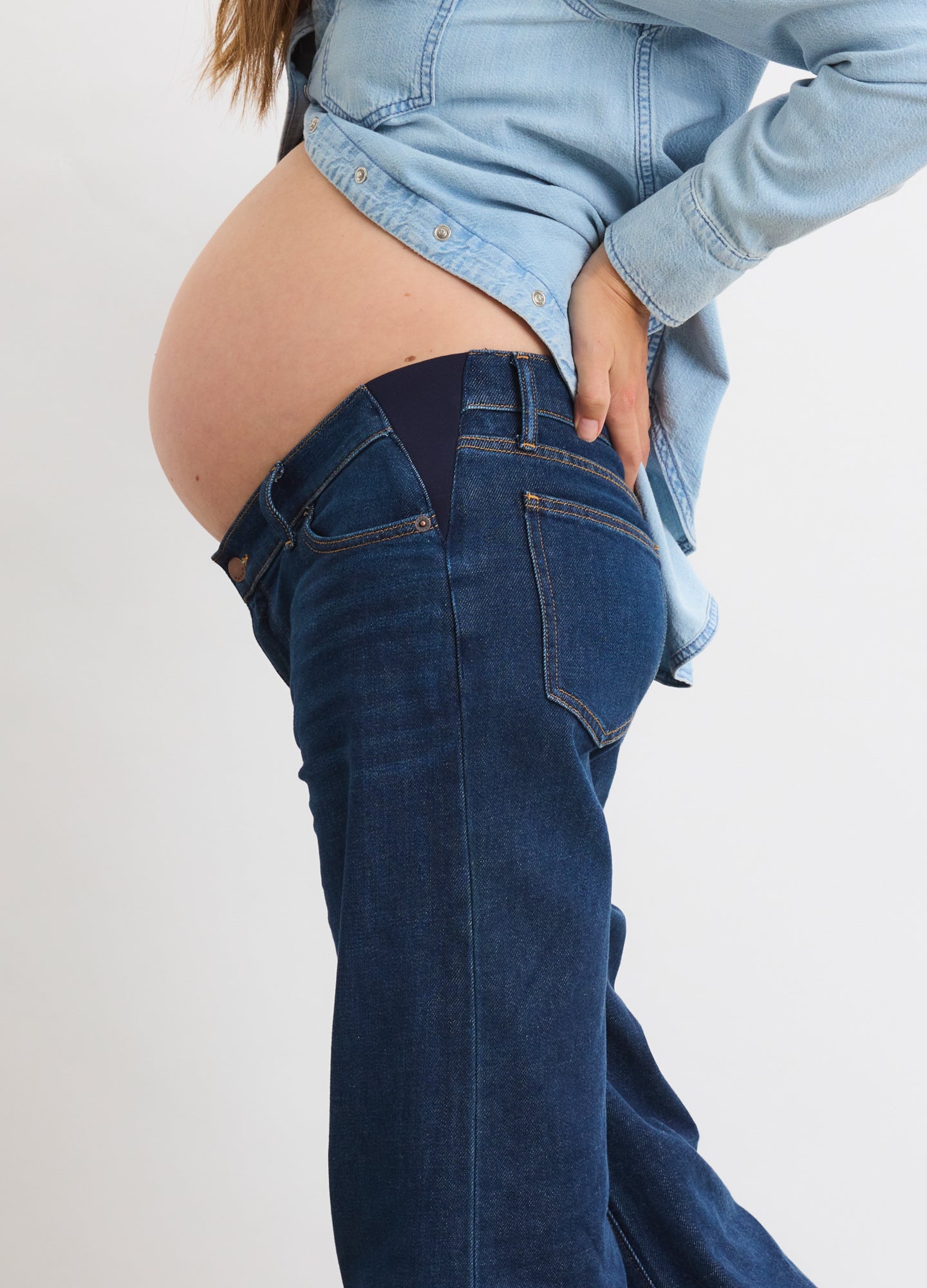 Dark blue denim maternity jeans with wide relaxed legs and a stretchy waistband accommodating a pregnant belly.