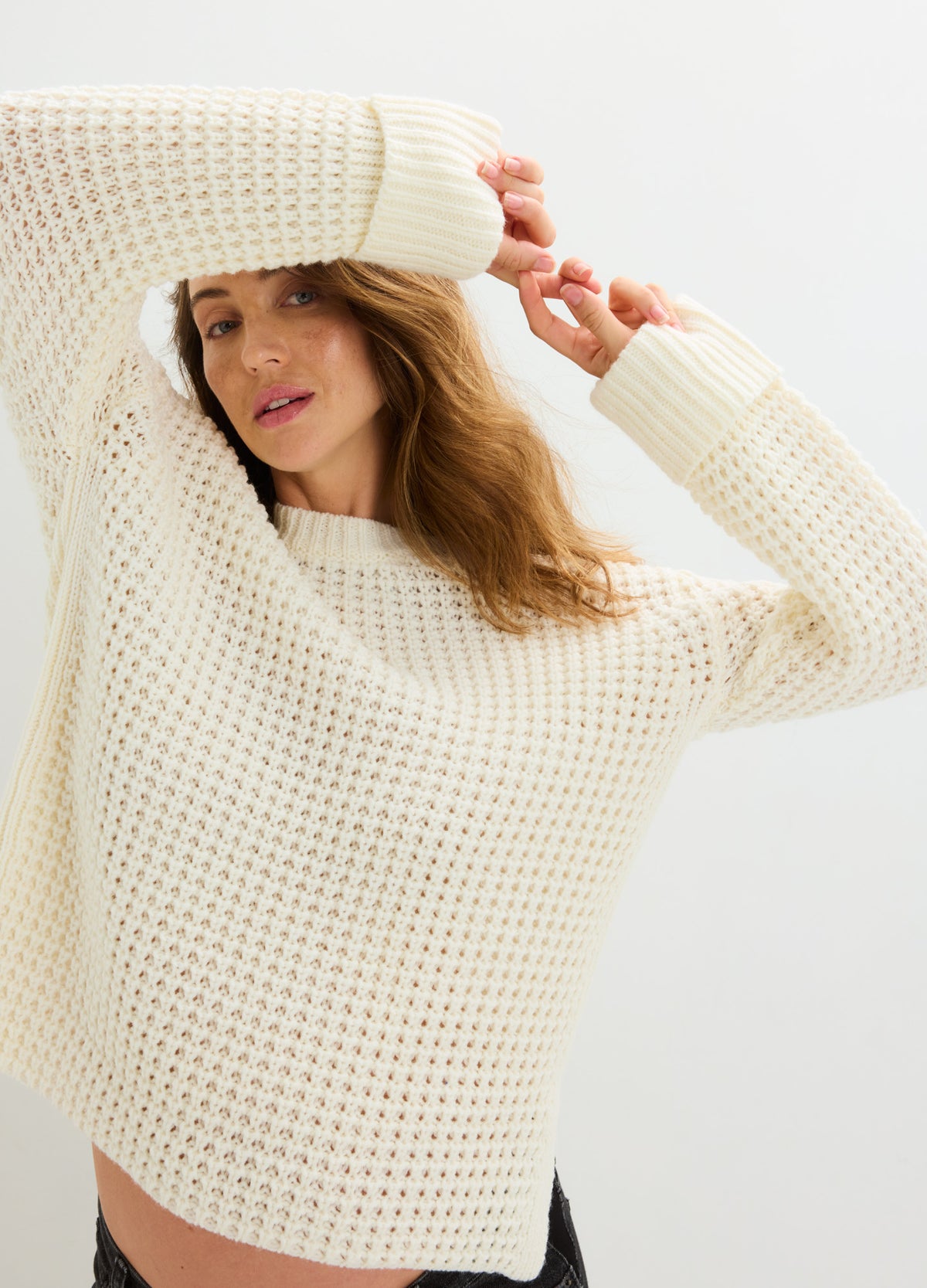Cream waffle-knit sweater with a relaxed fit, wide ribbed cuffs, and a large folded turtleneck collar.