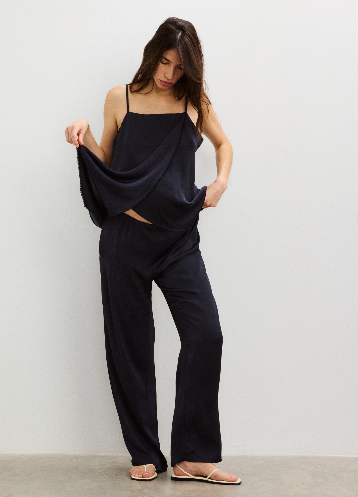 Black satin maternity pants with a relaxed fit and high elastic waistband, styled with a loose black camisole.