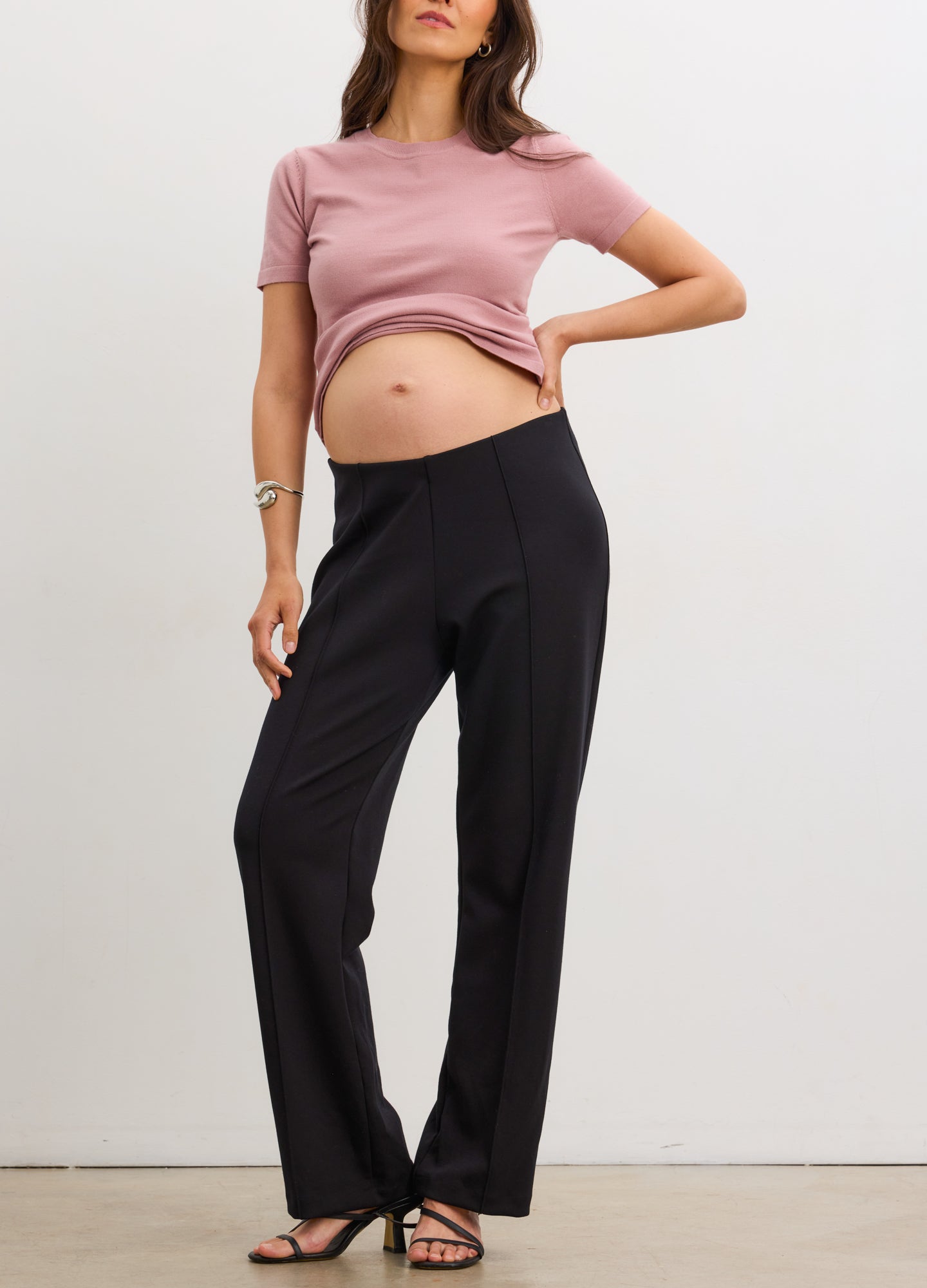 Black straight-leg maternity work pants with seamed detailing, stretchy fabric, worn by pregnant model.