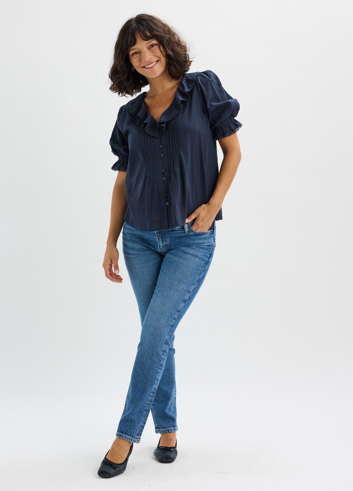 Blue slim-fit maternity jeans with stretchy waistband paired with navy short-sleeve blouse.
