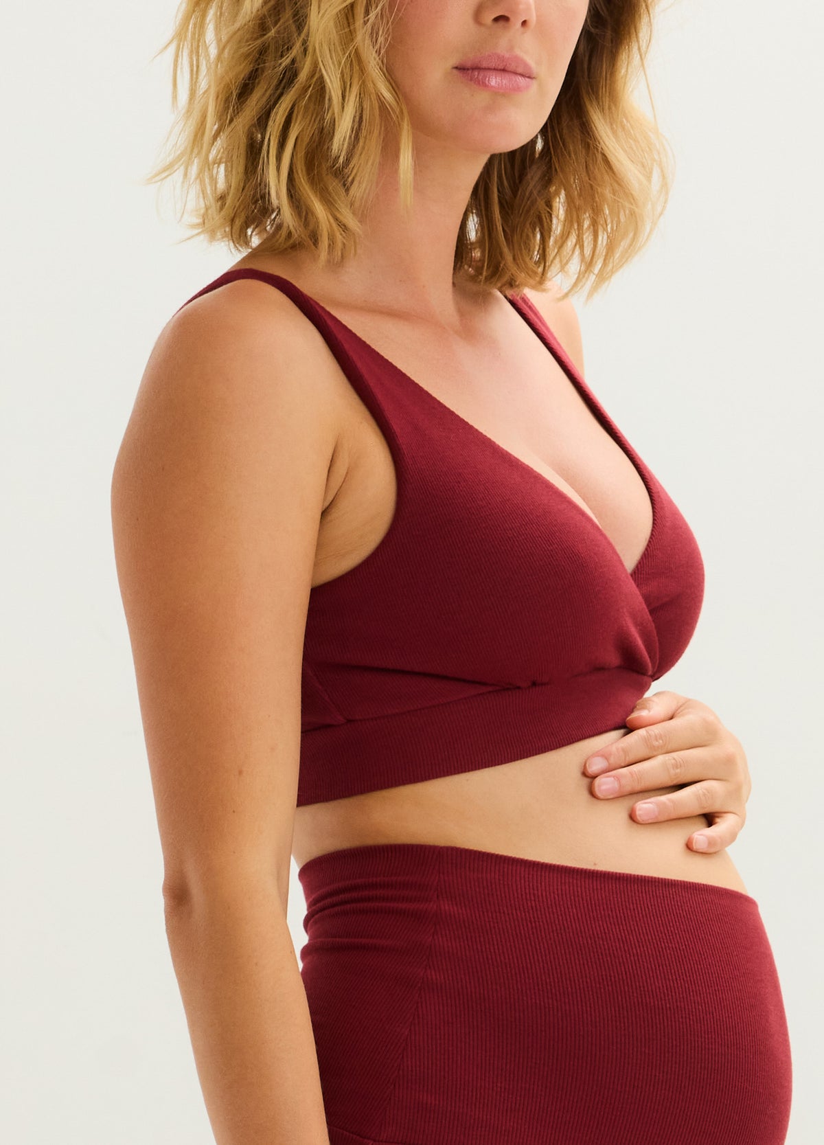 Cranberry ribbed maternity nursing bra with wide straps and a supportive crossover neckline.