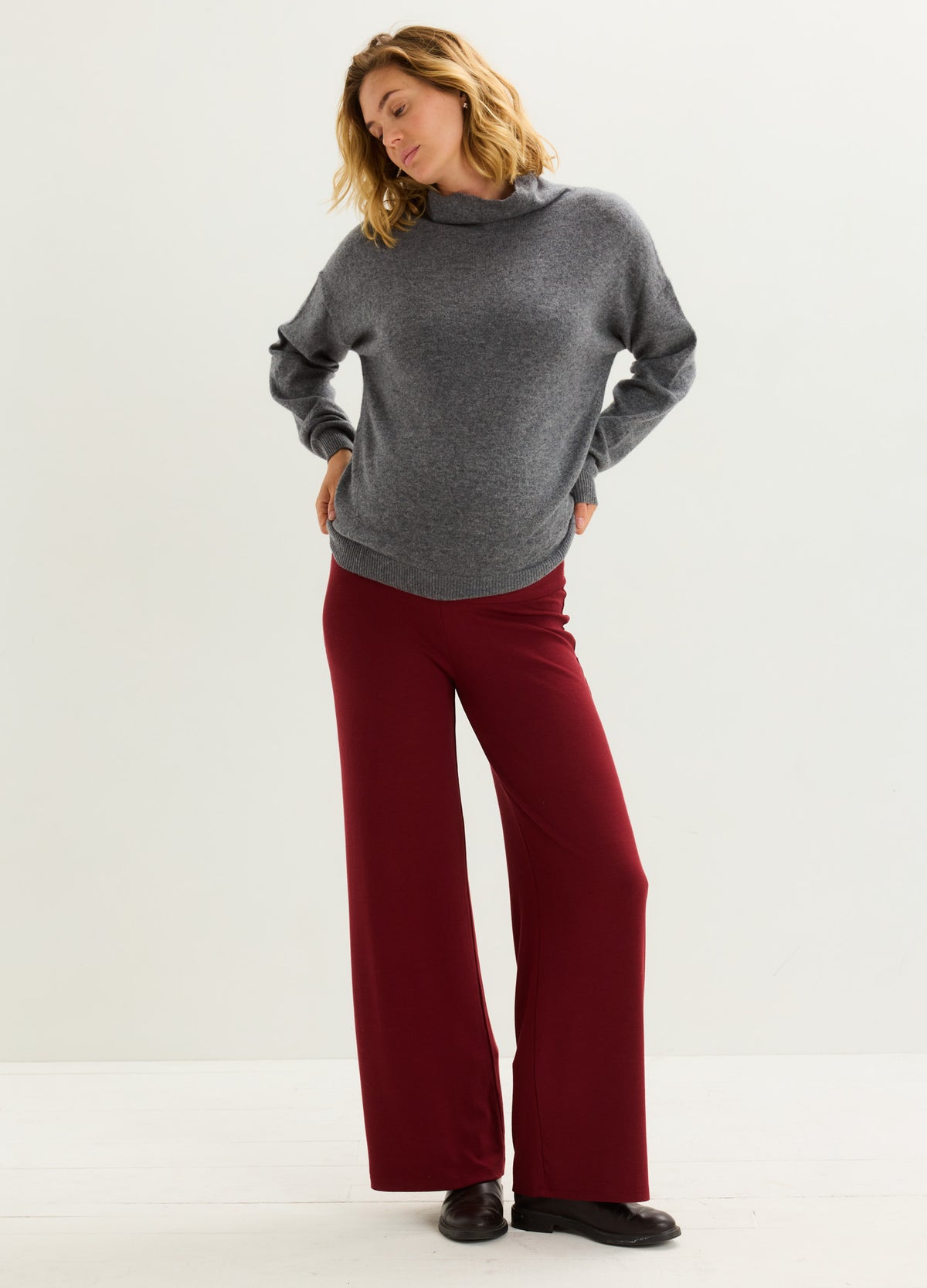 Maternity ribbed knit relaxed pants in deep burgundy paired with loose charcoal gray sweater.