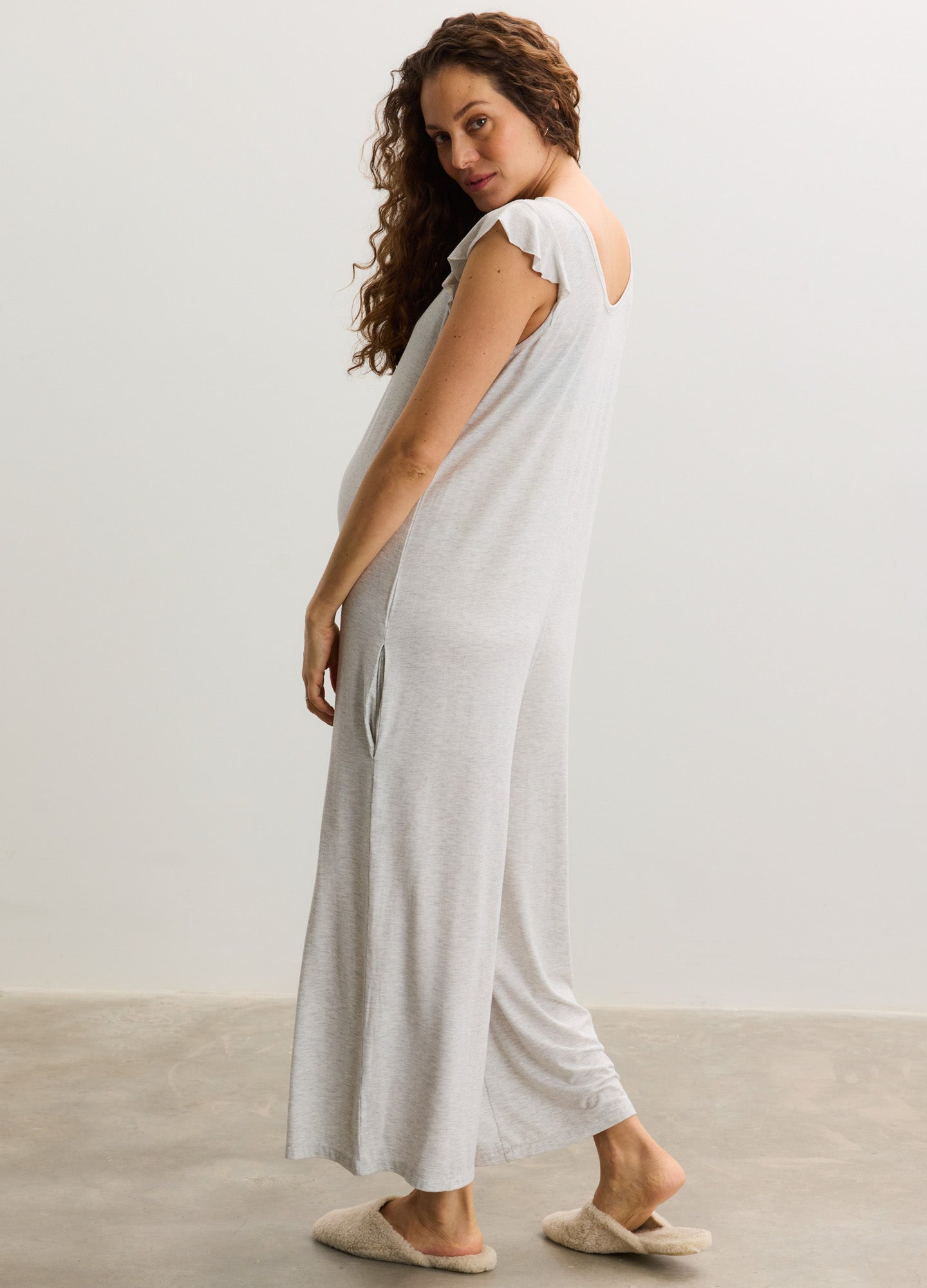Light gray sleeveless maternity jumpsuit with wide-leg pants and soft, flowing fabric.