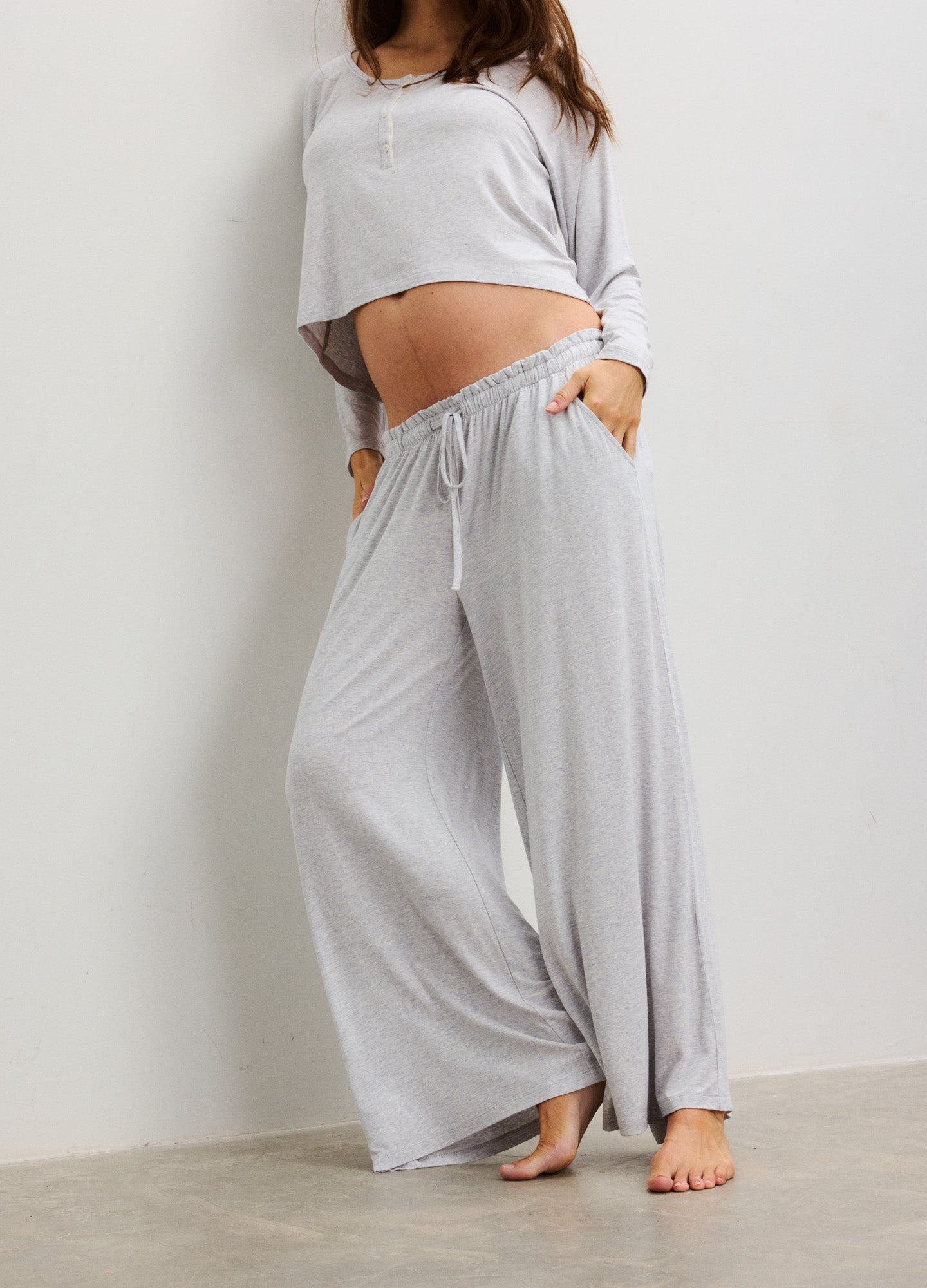 Light grey wide-leg maternity pants with a drawstring waist and soft, flowing fabric.