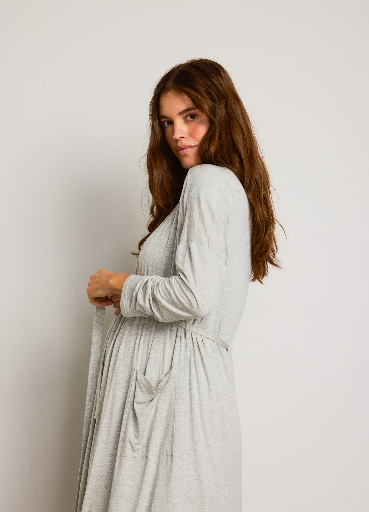 Light gray maternity robe in soft fabric with long sleeves and a tie waist belt.