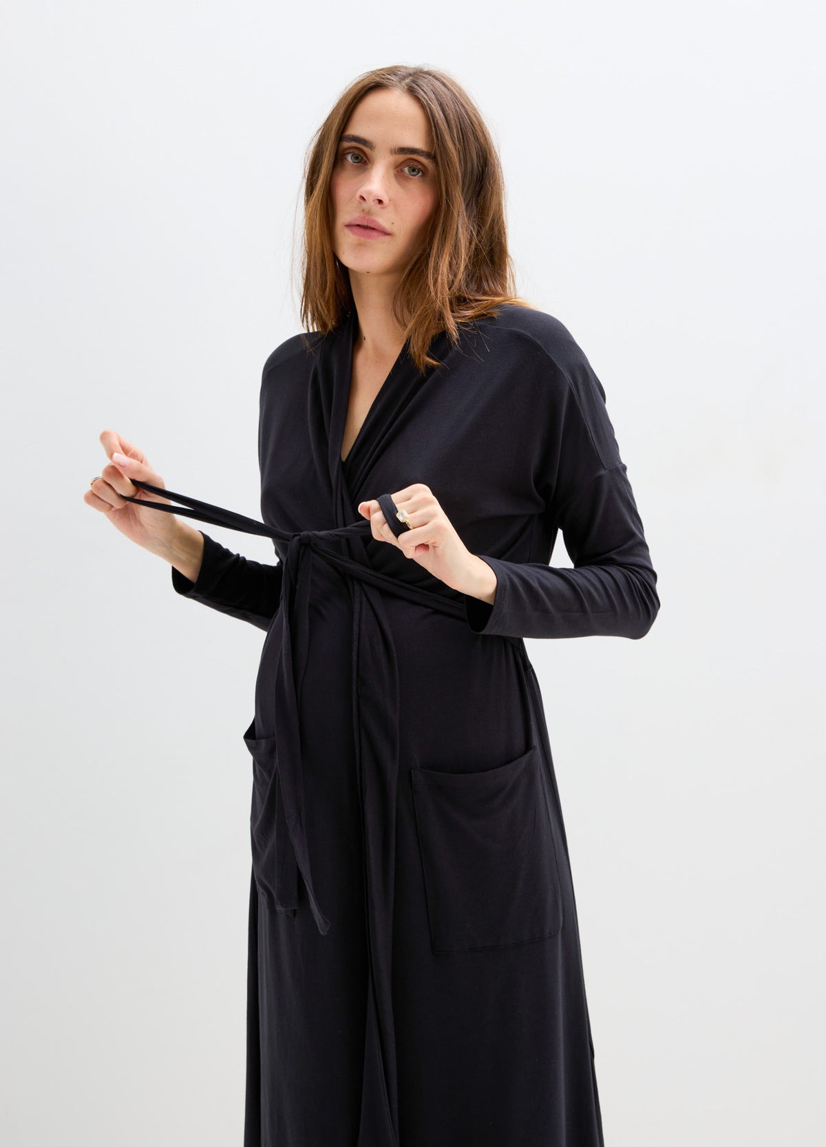 Black maternity robe with long sleeves, wrap tie belt, and two front pockets, soft fabric.
