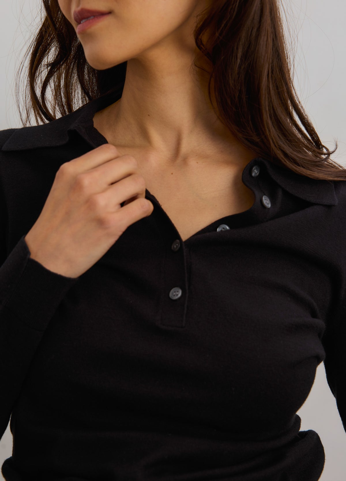 Black knit maternity nursing polo with button placket and soft collar, fitted silhouette.
