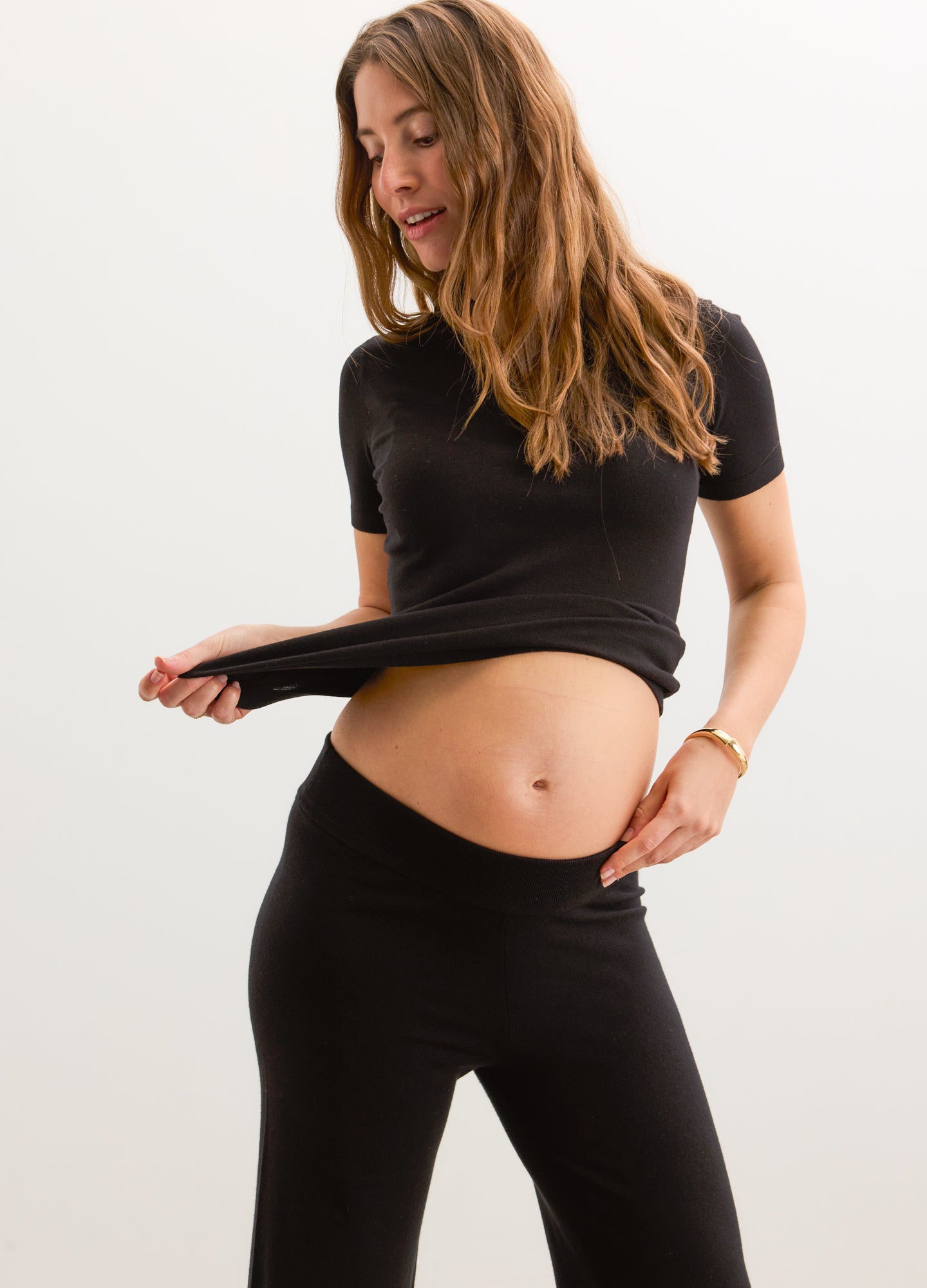 Black short-sleeve knit maternity tee with soft stretch fabric worn over belly.