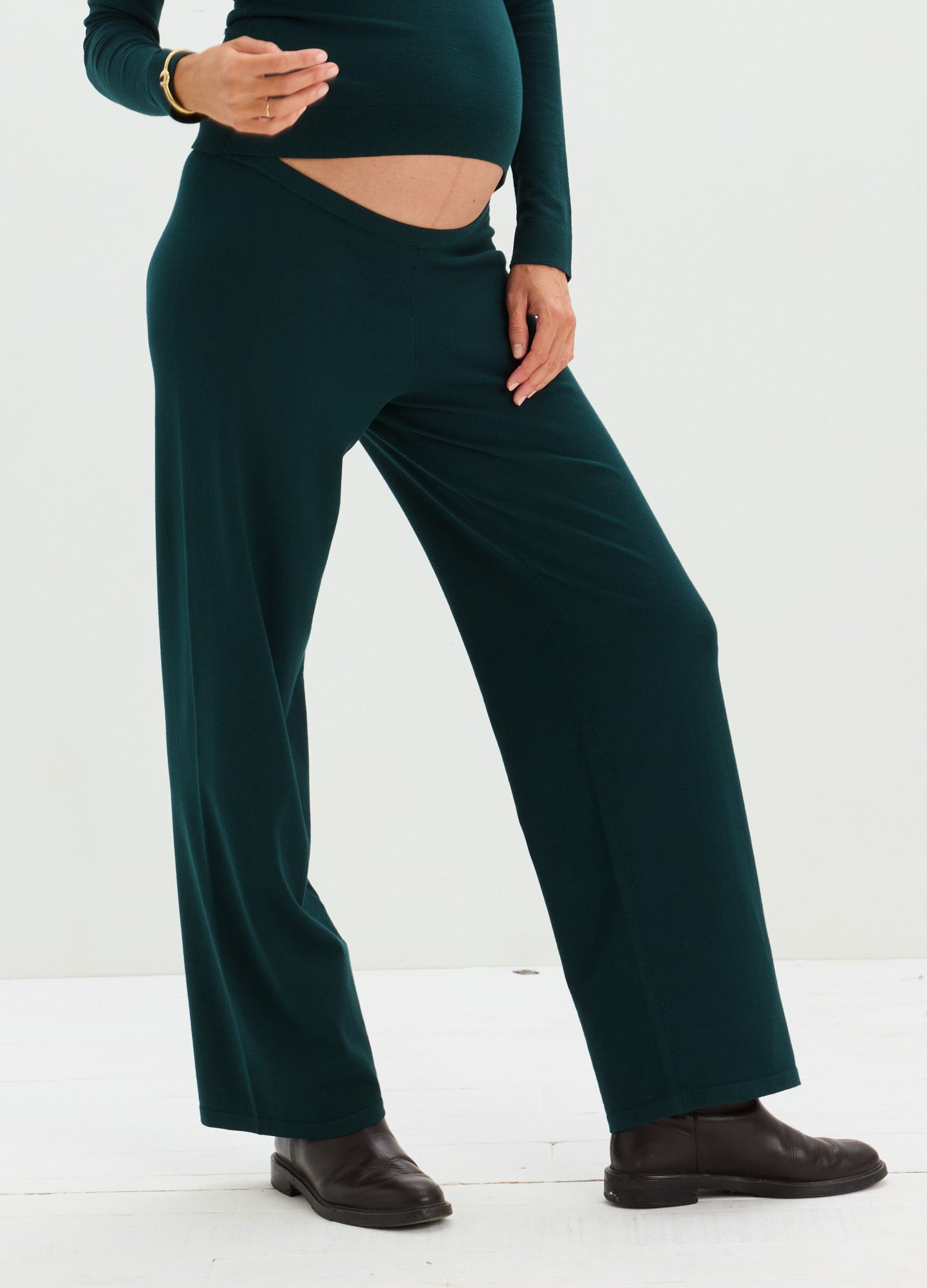 Dark green wide-leg maternity pants with a soft knit texture and a stretchy waistband designed for pregnancy comfort.