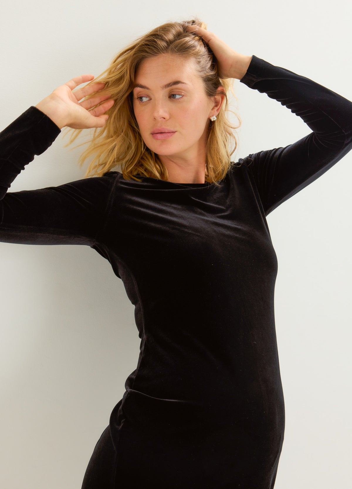 Black stretch velvet mini dress with a fitted silhouette, long sleeves, and a high neckline.