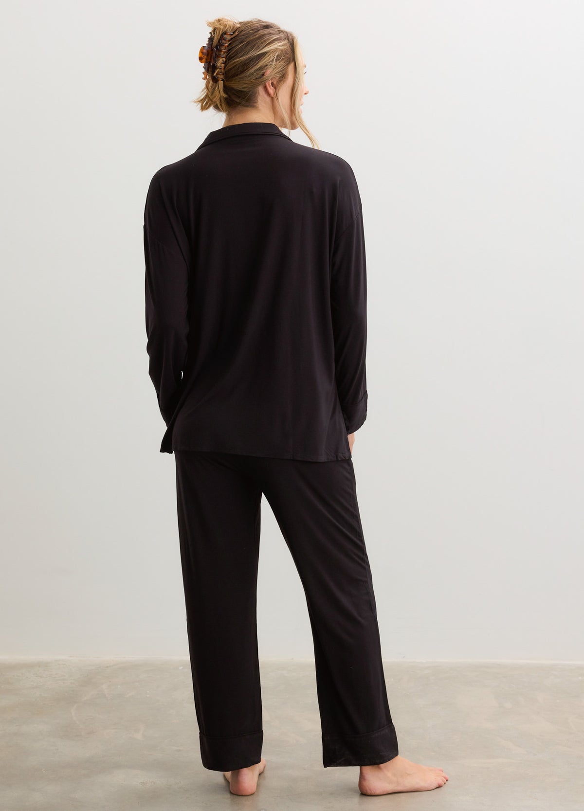Black maternity pajama set with long sleeves and relaxed straight-leg pants in soft jersey fabric.