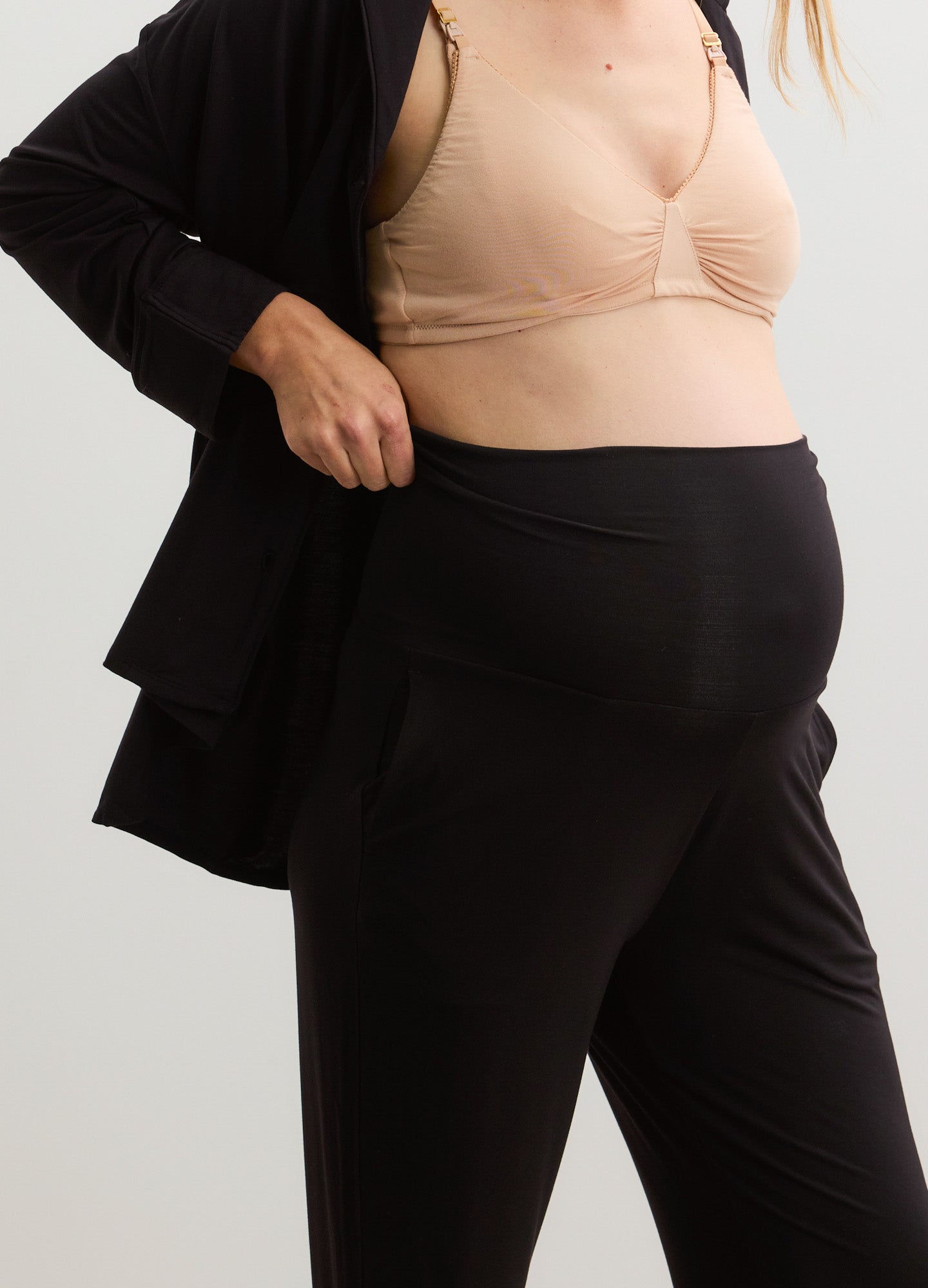 Black maternity lounge pants with a high elastic waistband paired with a nude soft jersey nursing bra and a black open-front