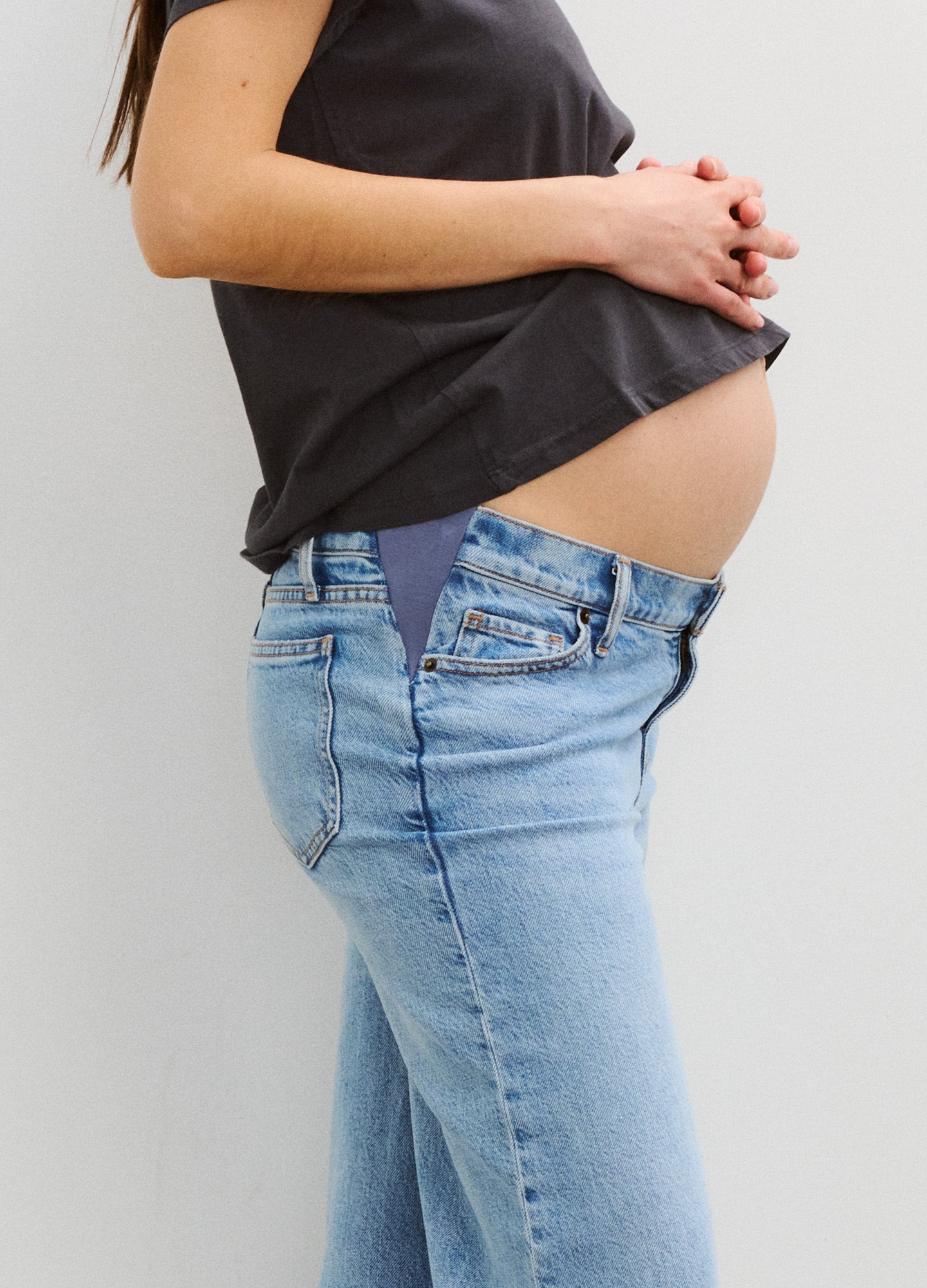 Light blue wide-leg maternity jeans with stretch panel at the waist, styled with a black top.