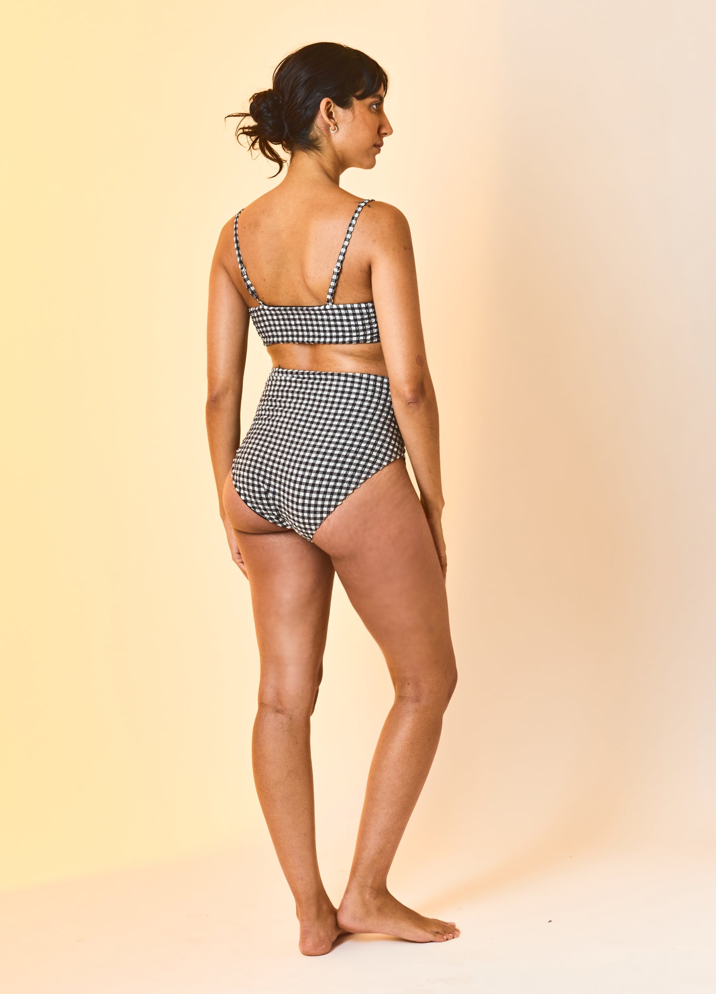Black and white patterned maternity bikini with adjustable shoulder straps and high-waisted bottoms.