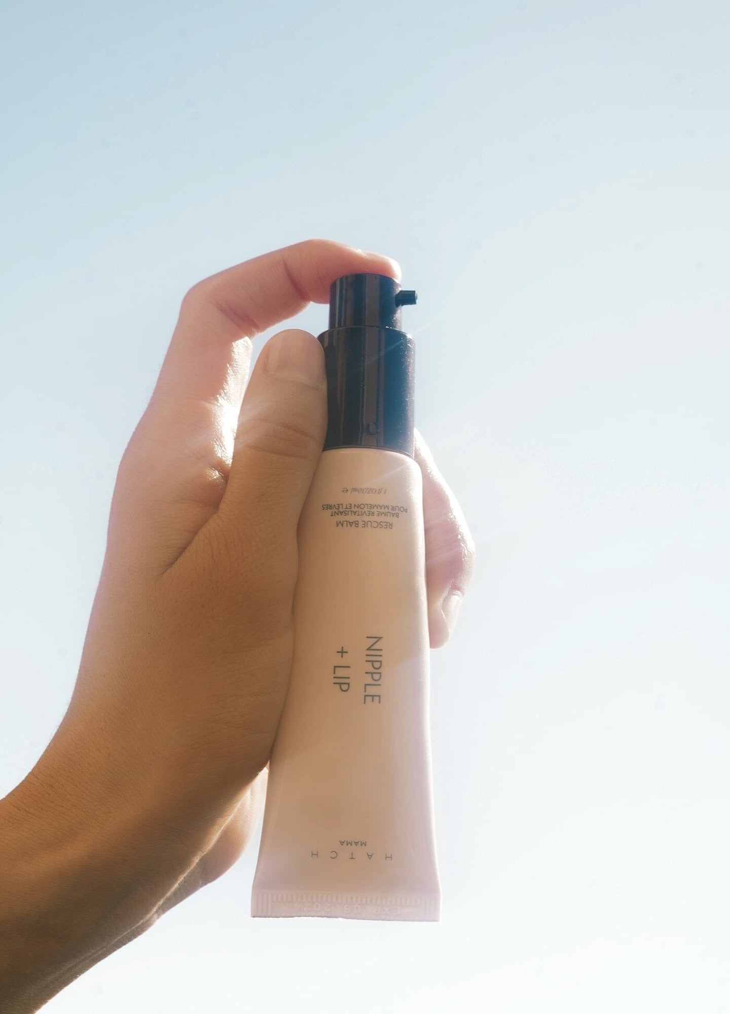 Nipple + Lip cream tube in hand with pump dispenser, designed for pregnant and maternity skin care, 1 oz/30mL.