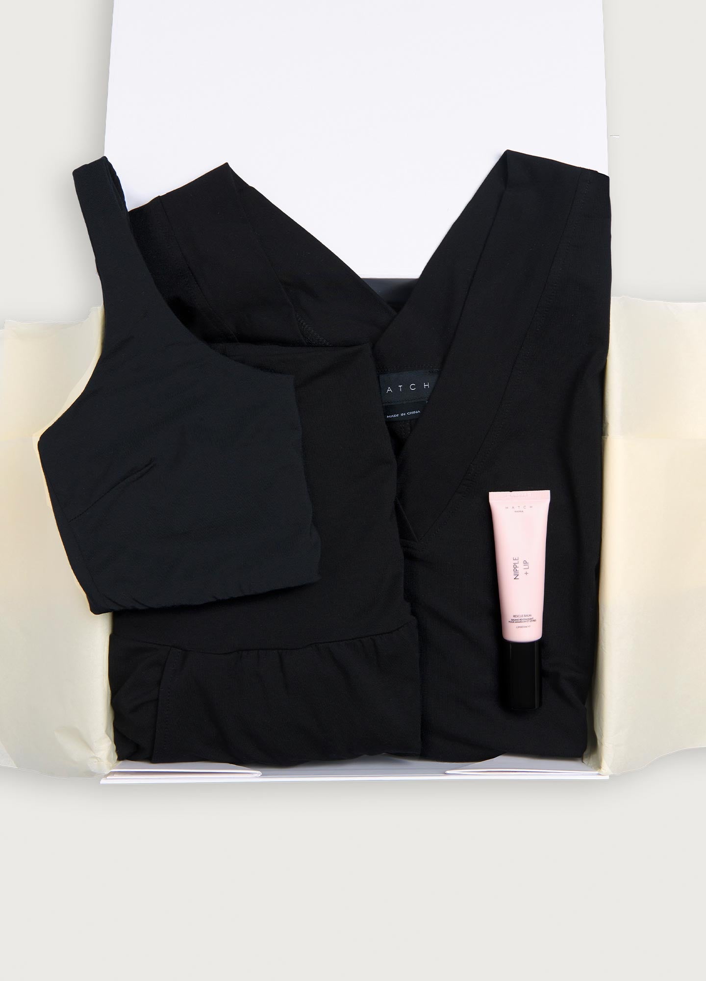 Black maternity tank top and pants set with soft fabric, paired with a pale pink skincare tube in gift box.