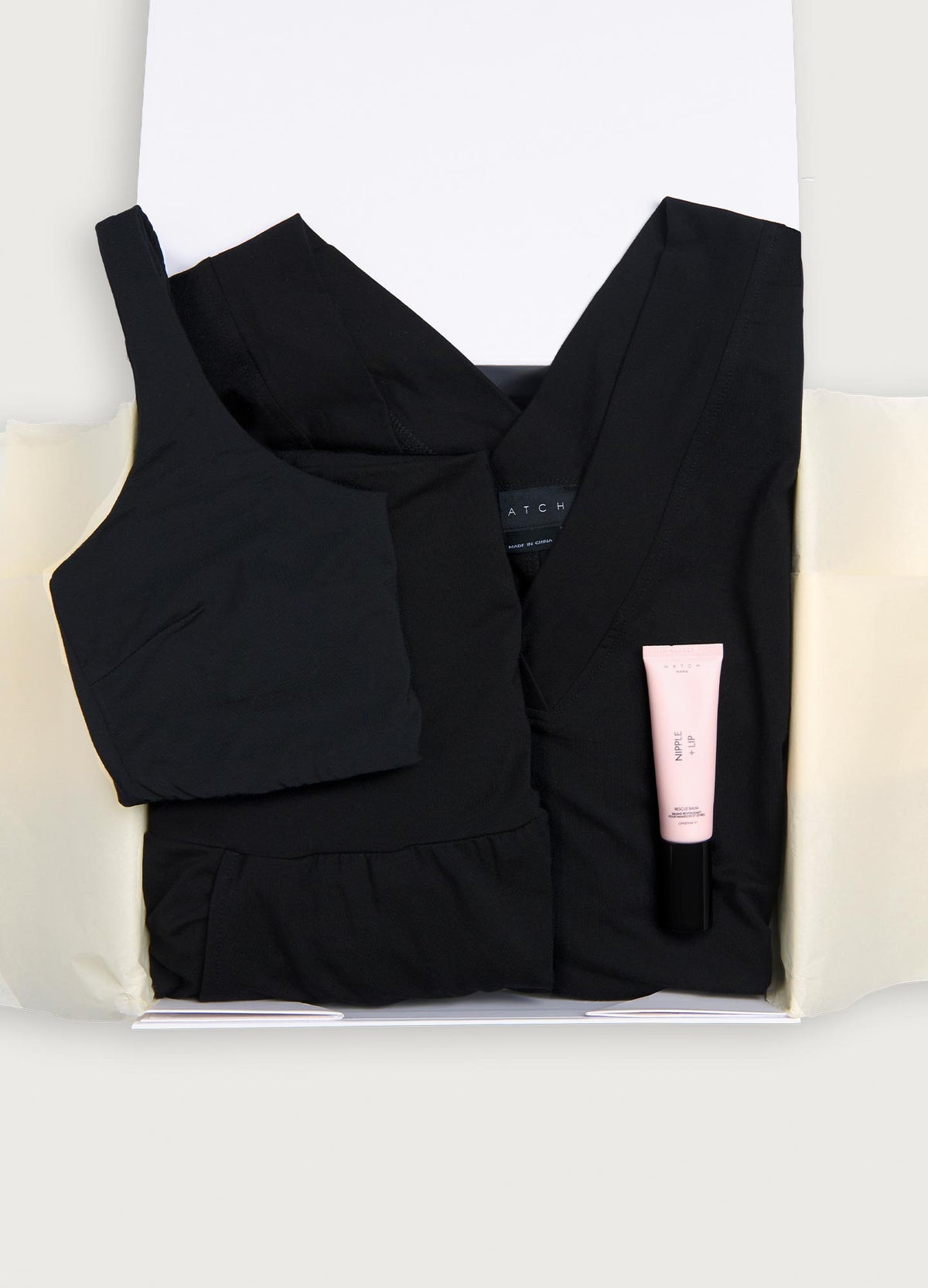 Black maternity tank top and pants set with soft fabric, paired with a pale pink skincare tube in gift box.